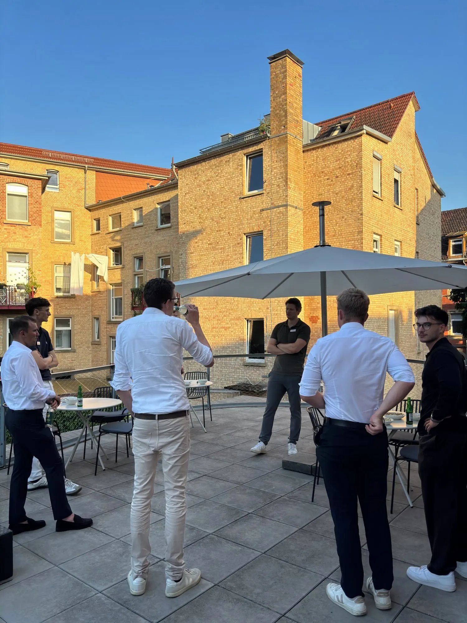 Mitglieder und Gäste im Gespräch auf einer Dachterrasse am Abend